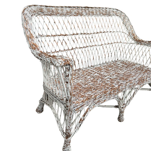Circa 1920s England, this antique willow wicker settee is truly a classic. Perfect for a sunroom, screened porch, covered...