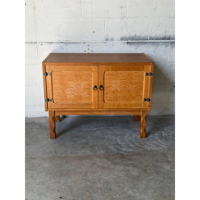 This functional storage cabinet features two paneled doors opening to reveal spacious interior shelving. Elevated on...