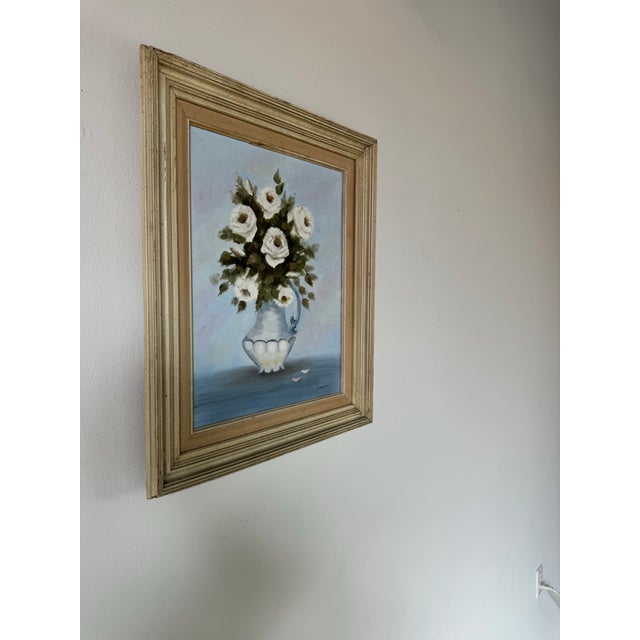 This charming vintage still life painting features a delicate bouquet of white roses arranged in an elegant, classical...