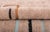 Fragments of structure, floating across a sandy field. Angular black and sand-toned lines trace open rectangles and right-...