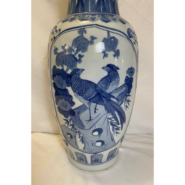 Vintage blue and white tall and stately porcelain/vase. One side has a mother and baby pheasant standing on a branch with...