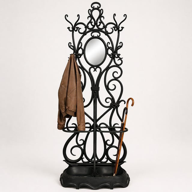 Striking wrought iron hall tree/coat rack with intricate scrollwork and an elegant oval mirror — a true statement piece...
