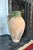 A beautifully time-worn terracotta vessel with a rich, organic presence and striking green glaze detail. The hand-thrown...