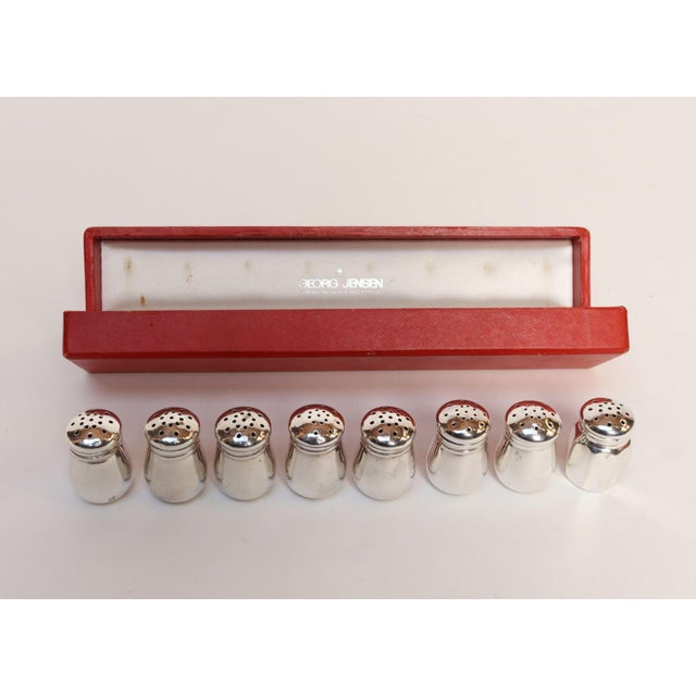 Partially complete set of seven miniature salt shakers by Revere Silversmiths with one added sterling silver shaker by JWW...