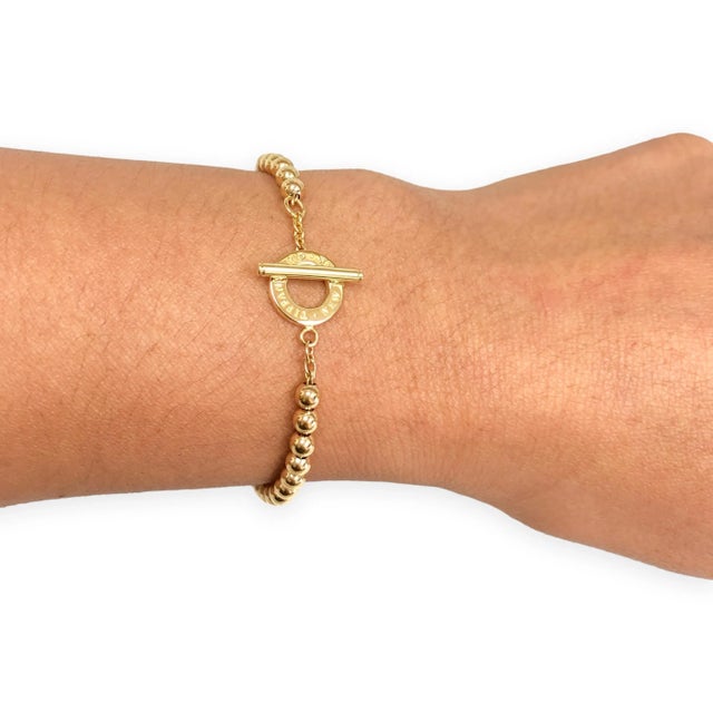 Vintage and rare Tiffany & Co. round-bead bracelet in solid 18K yellow gold with the signature engraved circular toggle...