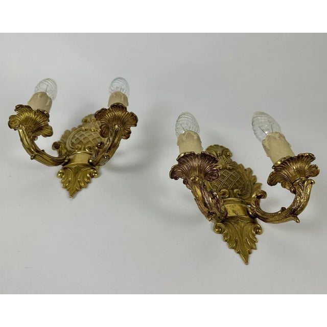 Pair of empire style wall lights manufactured in the 20th century. Bronze construction. Original gilding.The sconces are...