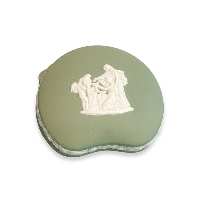 A beautifully crafted vintage Wedgwood jasperware trinket box in the brand’s classic sage green, adorned with crisp white...