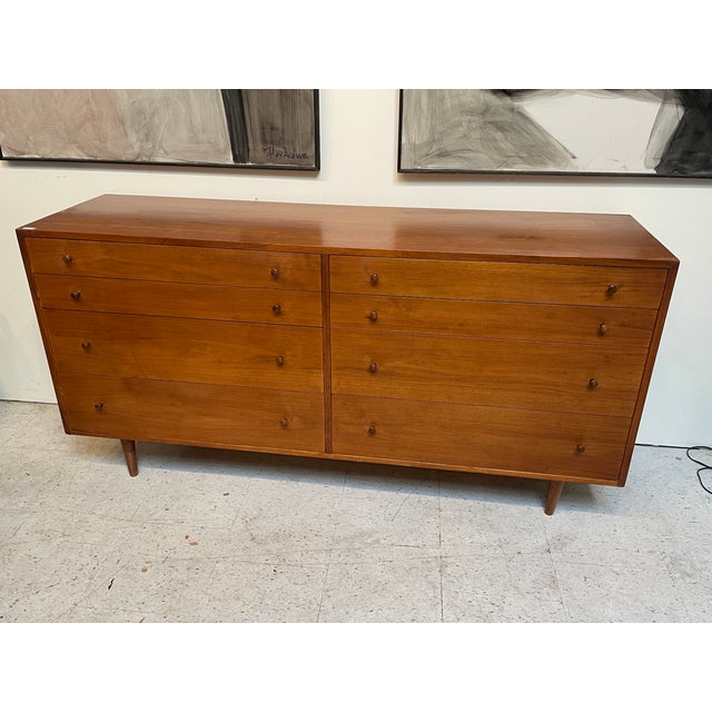 A stunning vintage walnut dresser . This piece embodies mid-century modern elegance and functionality with its 8 spacious...