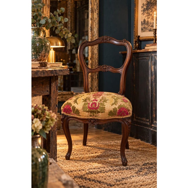 A napoleon iii style ball-back salon chair in dark-stained carved walnut. The back features a central almond-shaped...