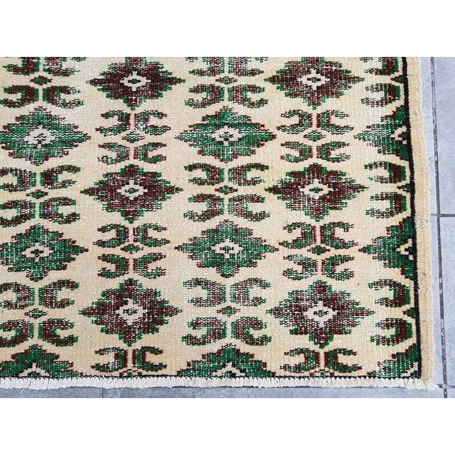 This is a vintage Turkish Oushak rug from the 1960s. The piece was hand-knotted.