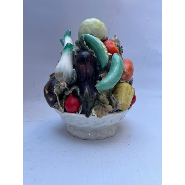 A single vintage porcelain basket stacked with vegetables.