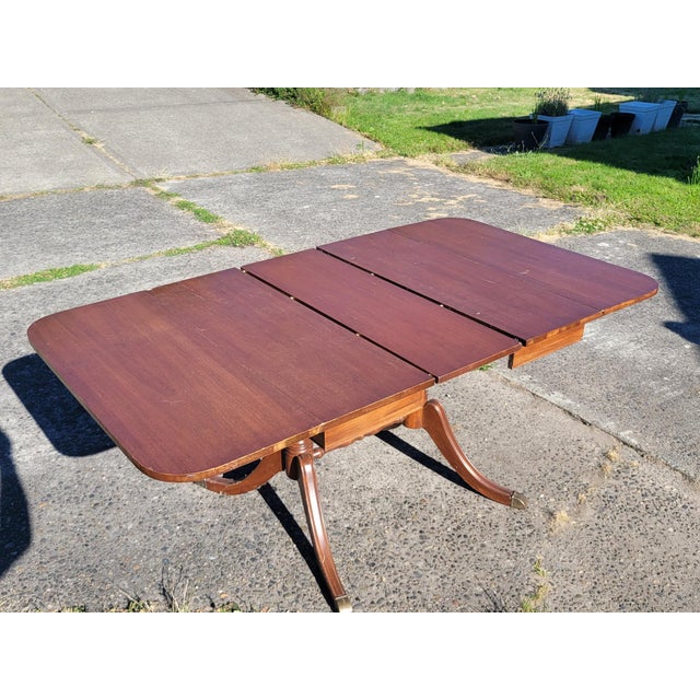 Drexel mahogany drop leaf table with additional leaf. Genuine Duncan Phyfe stamped on the bottom. Double pedestal base,...