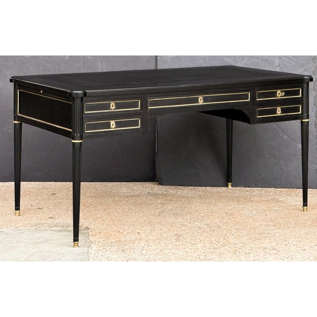 An elegant French bureau writing desk (or table) of ebonized mahogany, in the Louis XVI style. Featuring a moulded top...