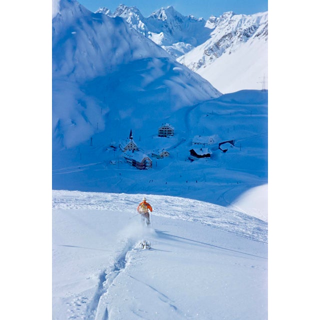 Snow Plough by Toni Frissell A lone skier heads down into the valley at the St. Anton ski resort, lying in shadow of one...