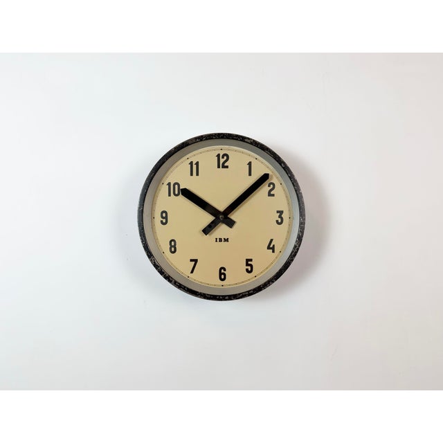 This wall clock was produced by IBM in USA during the 1950s. It features a black metal frame, iron dial, aluminium hands...