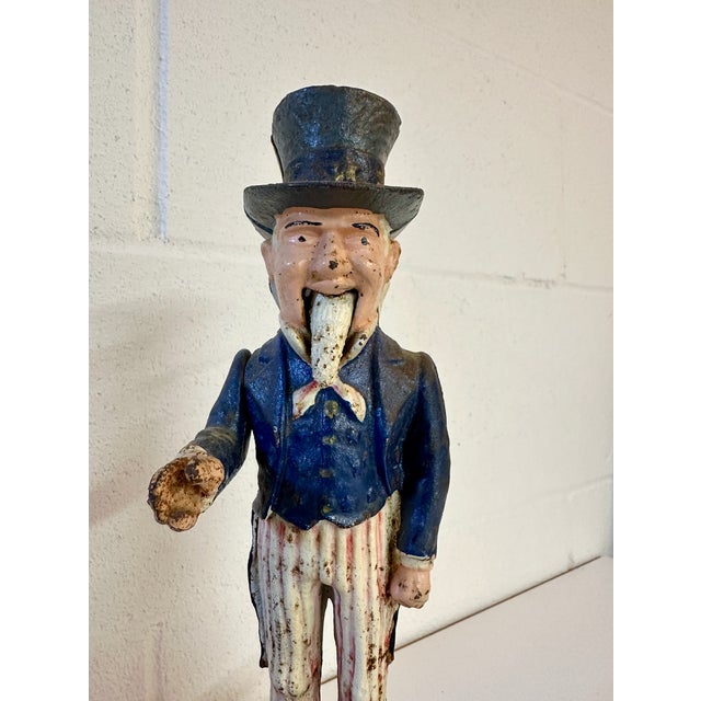 Vintage Uncle Sam mechanical bank. When button is pressed, the beard and arm come and the bag opens to drop the coin....