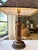 Elegant vintage table lamp featuring a substantial carved wood column with a distinctive spiral-carved detail and tiered...