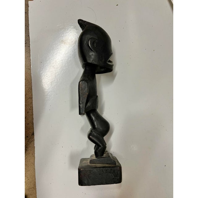 This is a 13” hand carved wood statue of a village person. The inscription impressed in the base reads:"HANDCARVED IN...