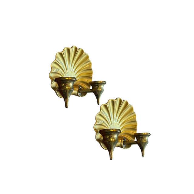 A charming pair of vintage candle sconces. Each features a cast metal, shell firm back plate with double, brass candle...