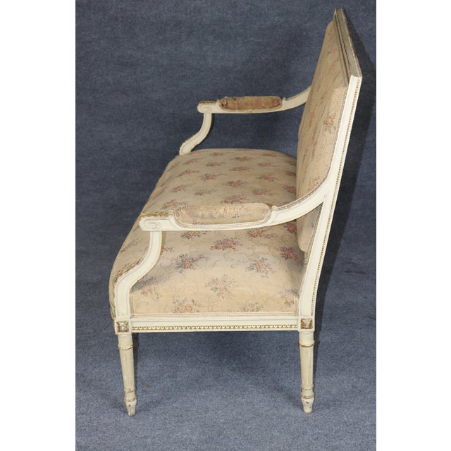This is a charming French Louis XVI–style painted settee, dating approximately to the 1930s–1940s. The elegant two-seat...