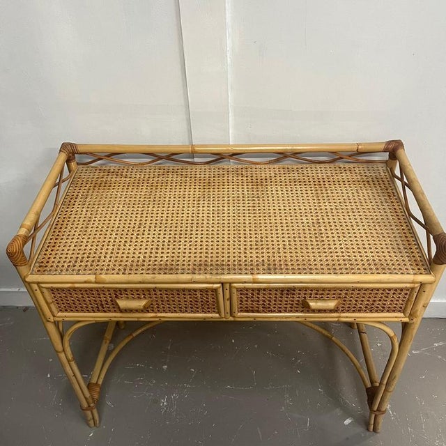 Cane and bamboo dressing table with 2 drawers with bamboo handles. It has a gallery edging and a glass top covering cane ....
