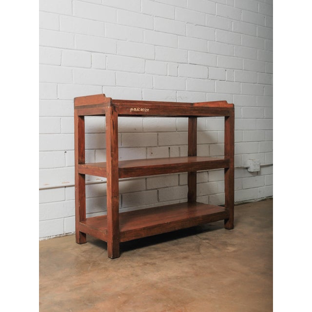 This vintage solid wood shelving unit features a clean, architectural form paired with a richly aged surface that...