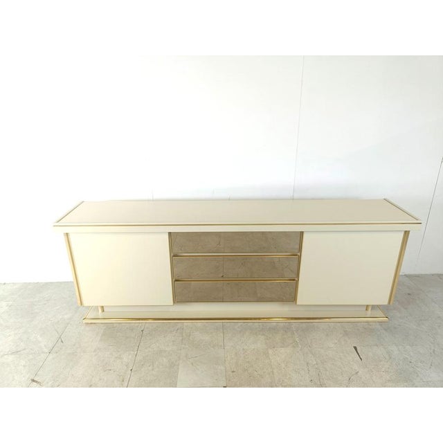 Luxurious seventies glamour sideboard consisting of two sliding doors and three smoked mirrored glass drawers. The use of...
