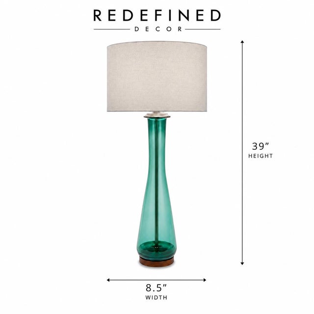 A sculptural mid-20th century table lamp in a striking turquoise art glass body, hand-blown with visible texture and depth...