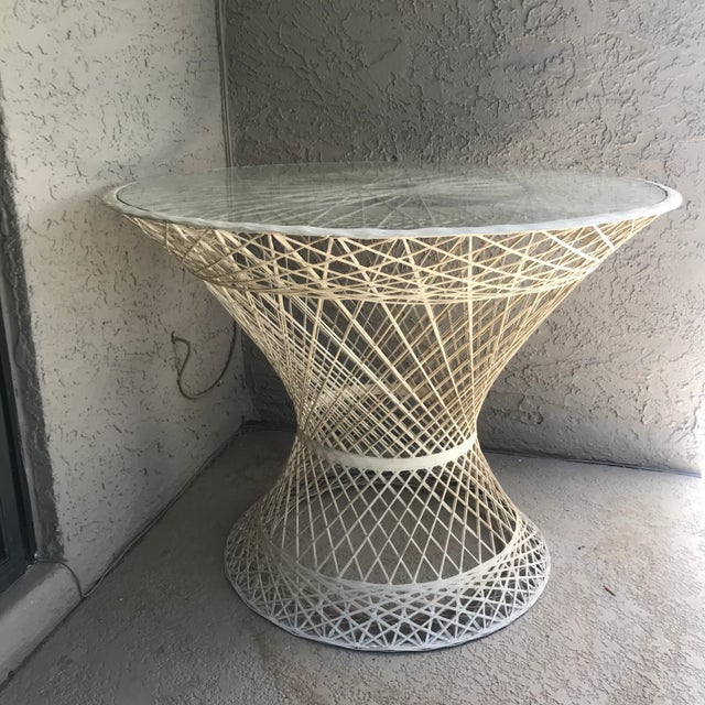 Timeless and versatile, lightweight and indestructible, this spun fiberglass patio table ascribed to Russel Woodard with a...