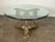 This is a unique coffee table featuring a round glass top and an intricately carved gilt wood base. The base is made of...