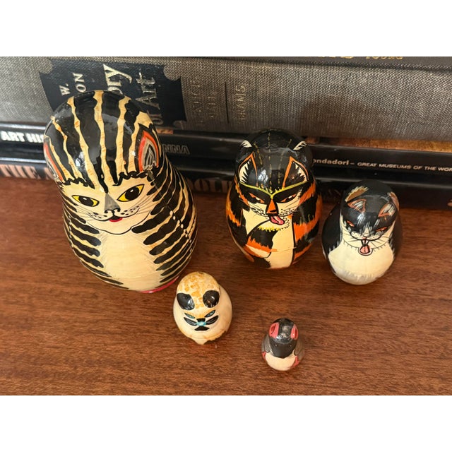 Whimsical set of late 20th century folk art nesting dolls, 5 in total. The nesting dolls are made up of 4 cats with the...