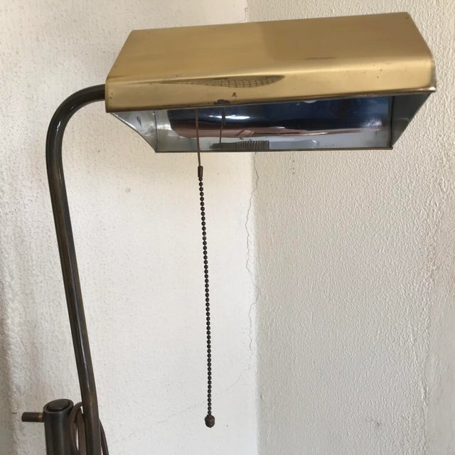Adjustable brass floor lamp on a granite base. Good condition, small discoloration on the brass and a dent on the granite...