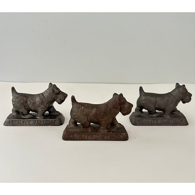 Three vintage cast iron Scottish terrier paperweights from Hamilton Foundry of Hamilton, Ohio. Each stands on an integral...