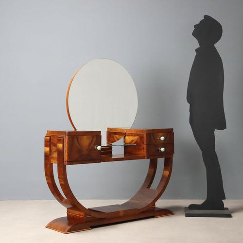 Art Deco dressing table with walnut veneer. Circular mirror, small glass shelf; front with a pair of drawers and a door....