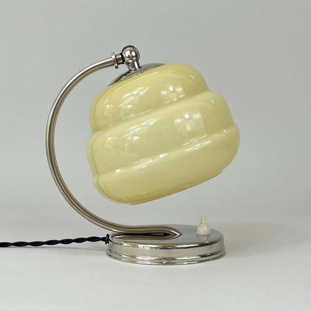 This art deco table lamp or bedside light was designed and manufactured in germany in the 1930s during the bauhaus period....