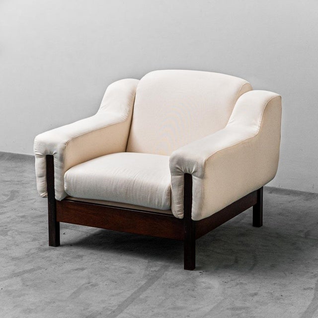 Pair of armchairs produced by Saporiti around the 70s. Light fabric covering. Wooden structure. Excellent condition, with...