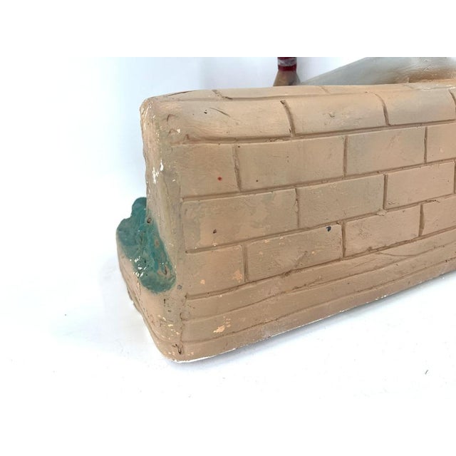 Rare plaster advertising sculpture depicting a Martini Jockey sitting next to a martini sign on a wall holding a glass....