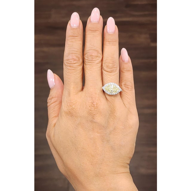 A captivating 2.36-carat GIA-certified marquise-cut diamond commands attention, showcasing a yellow hue with SI1 clarity...