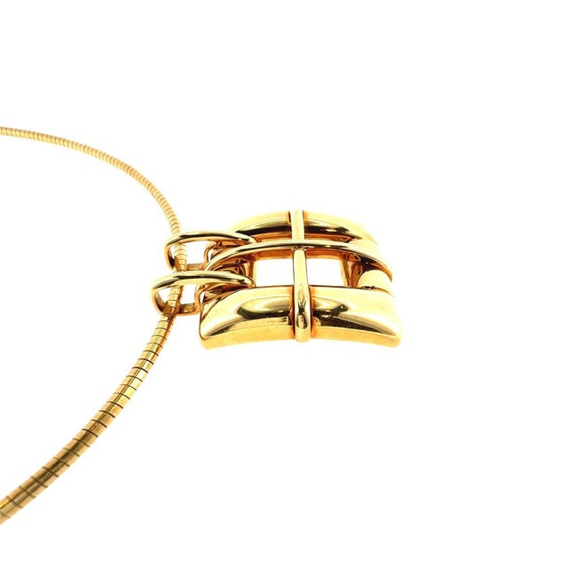 Vintage Tiffany & Co. 18K Gold buckle style pendant from the 2001 collection with a 2.5 mm Omega wire chain. Measurements:...