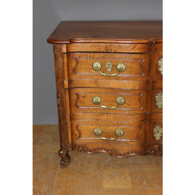 A Louis XV commode, known as a "crossbow" commode, with four drawers in three rows. One of the drawers conceals a secret...