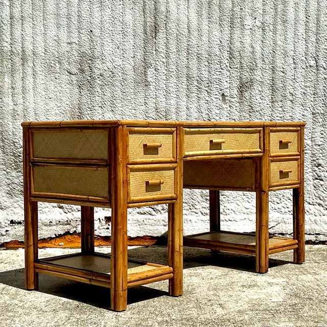 A charming vintage coastal writing desk crafted from woven rattan, offering a relaxed, beachy feel with a touch of natural...