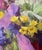 Lanterns presents a vibrant arrangement of yellow flowers against a backdrop of rich purples and greens, evoking a sense...