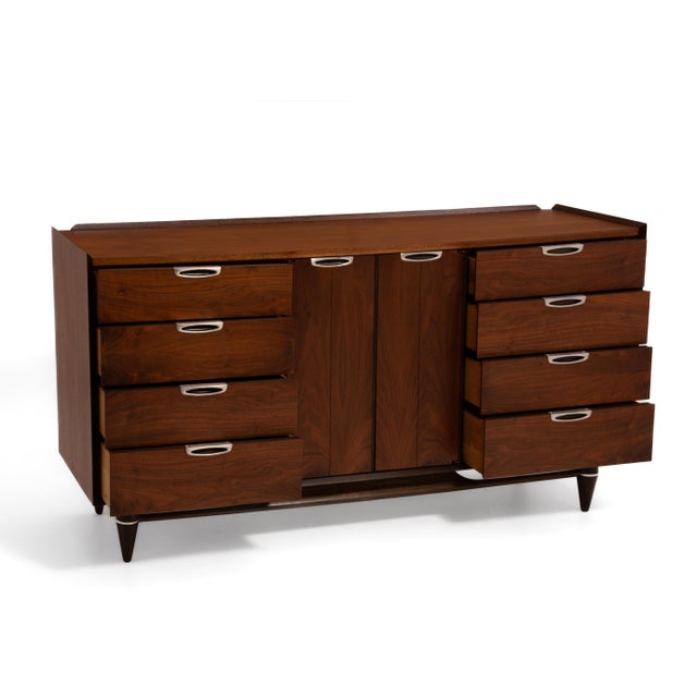 A Mid Century walnut dresser by Broyhill Premier Division. Reminiscent of the Lane "First Edition" Line, the dresser...
