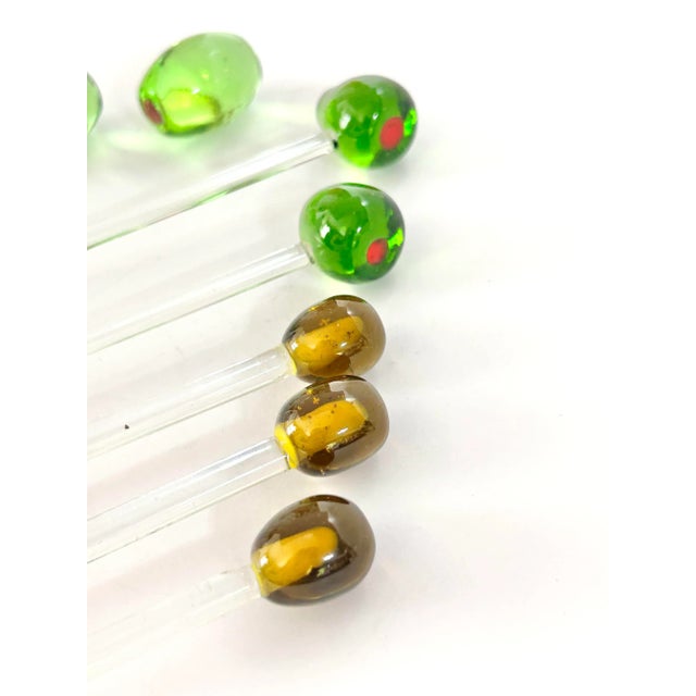 A charming set of art glass cocktail swizzle sticks topped with olive forms in shades of green and amber. Inspired by...