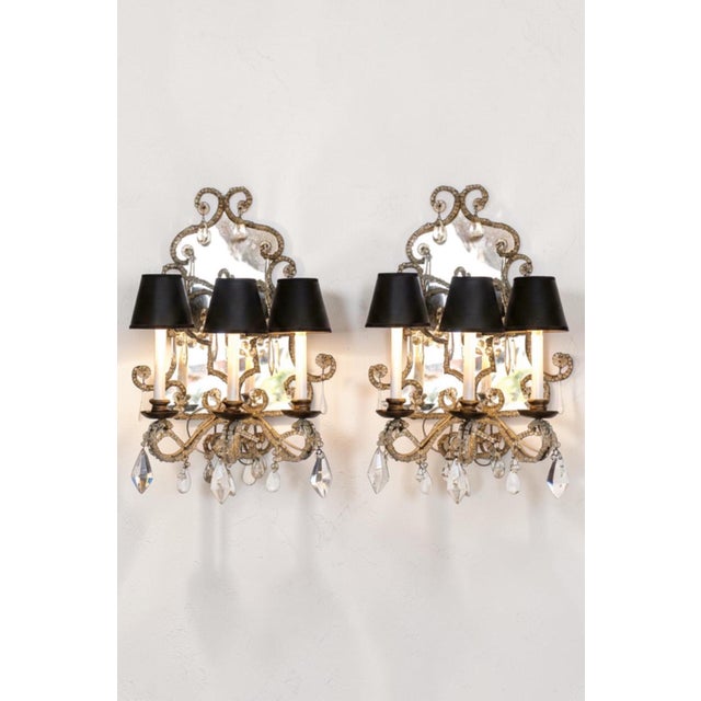 A striking pair of antique Italian wall sconces featuring mirrored backplates, delicate petite beading, and sparkling...