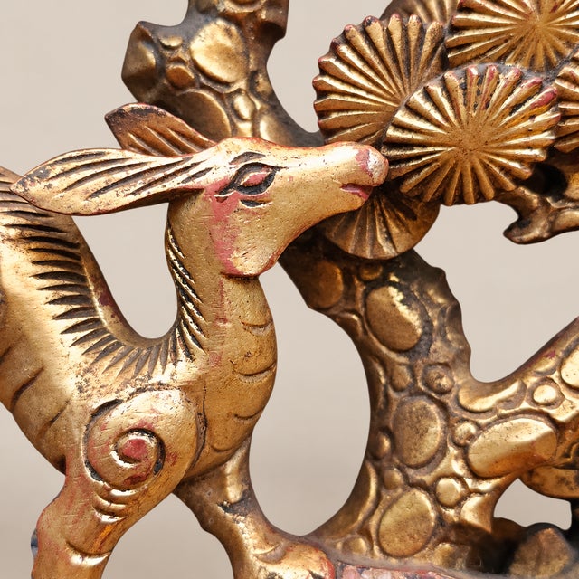 A charming Chinese carved giltwood openwork panel depicting a stylized deer beneath a pine tree, likely early to mid-20th...