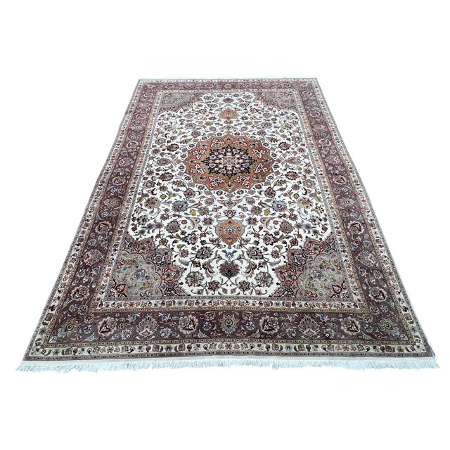 Fine Persian Tabriz rug, hand knotted in Iran with a 100% wool pile and delicate silk highlights. Measuring 6’7” x 10’2”,...