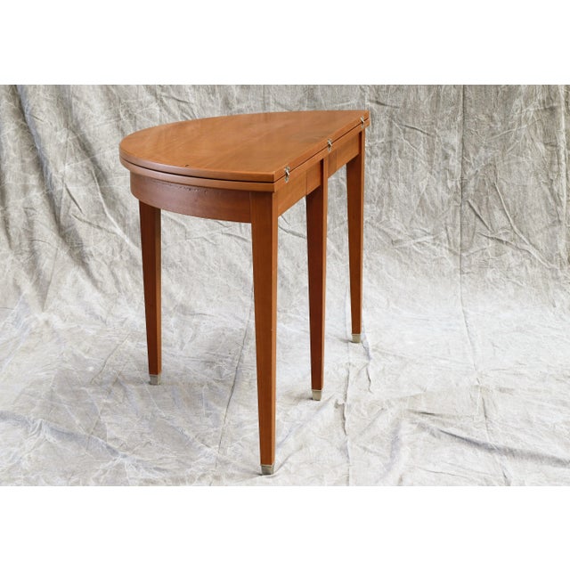 The table is foldable and becomes a round table of 121cm. diameter, folded is a wall console 61cm. deep and 121cm. long.