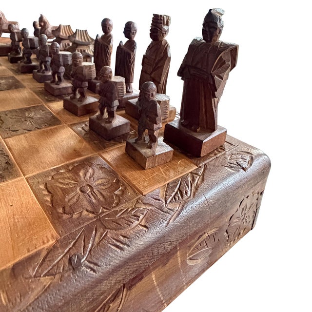 A wonderfully sculptural vintage hand-carved figural chess set, featuring an elaborate folding wooden game board and a...