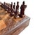 A wonderfully sculptural vintage hand-carved figural chess set, featuring an elaborate folding wooden game board and a...